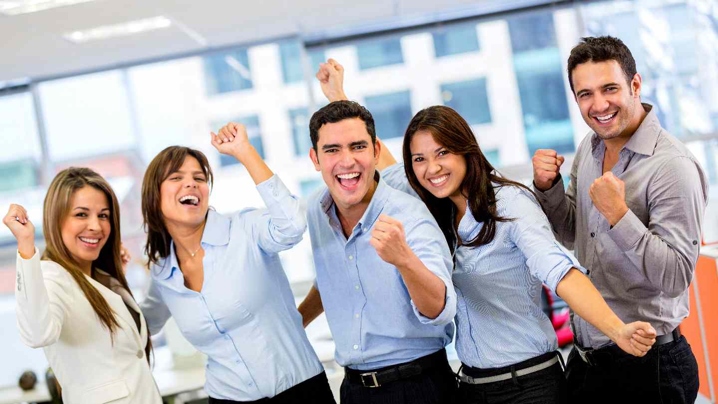 Successful business group with arms up at the office Salvere Institut